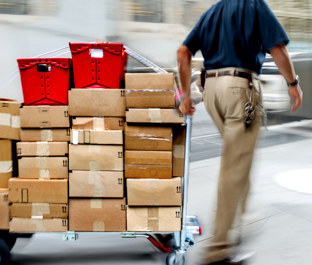 man delivering goods with dolly by hand.