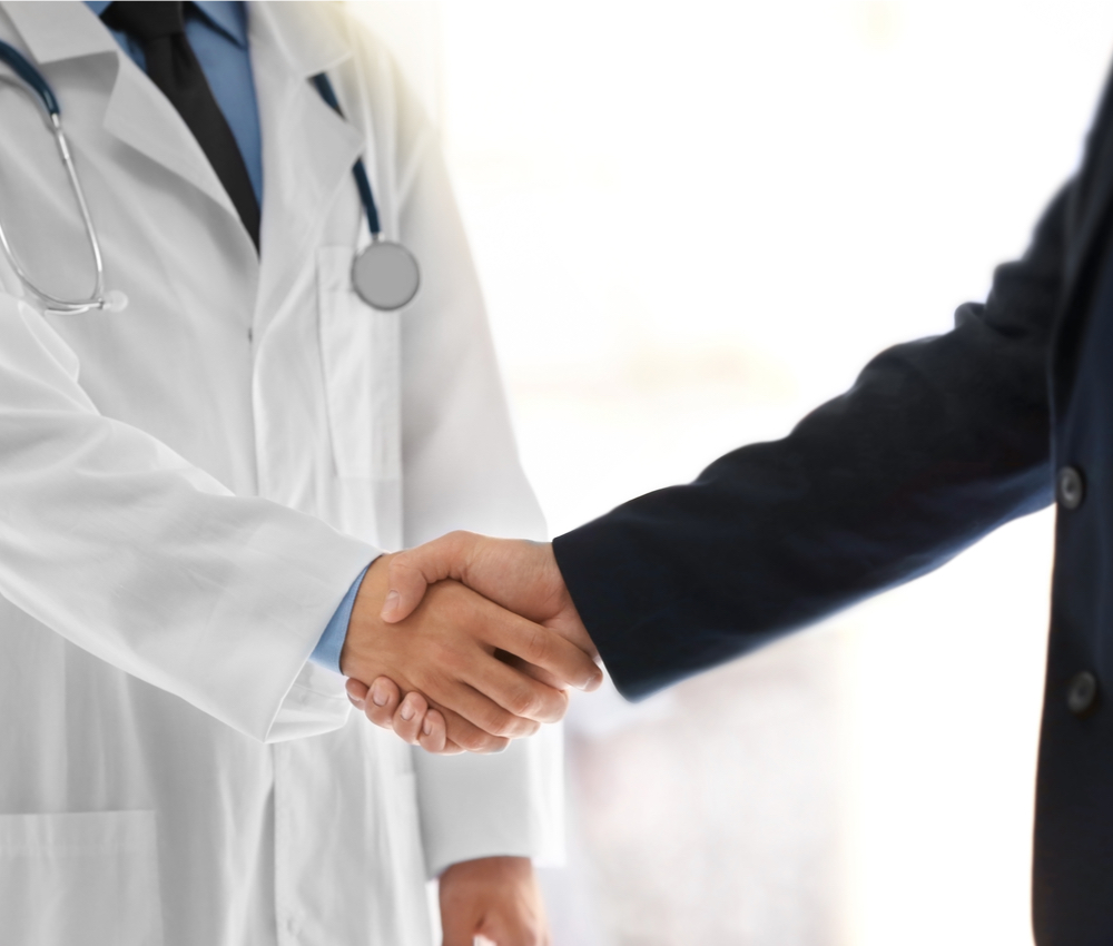 Doctor hand shaking with man in hospital