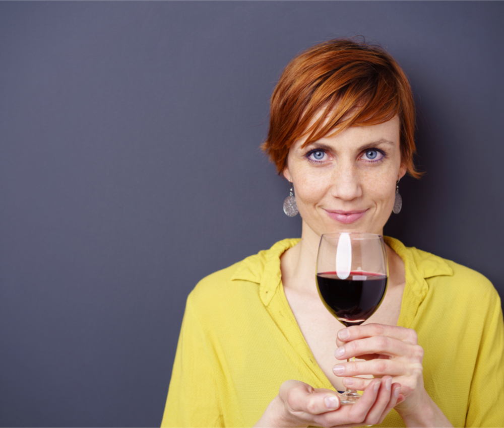 woman holding a glass of wine in front of herself