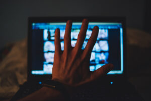 A hand over a computer screen