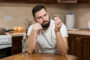 Man examining shot glass.