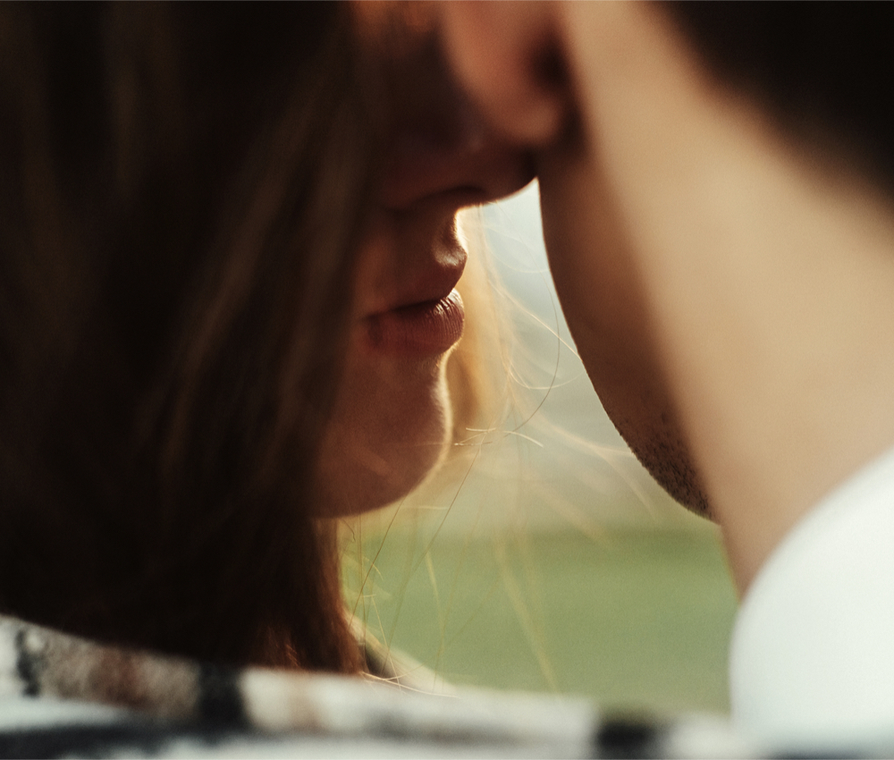 a woman with her nose to a man's cheek