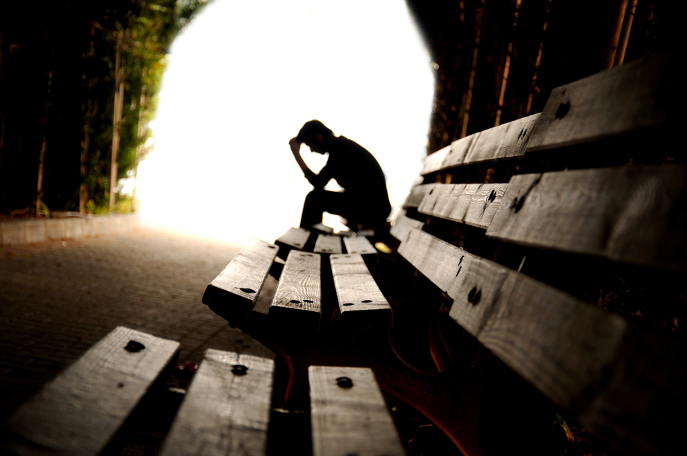 troubled teen sitting on park bench