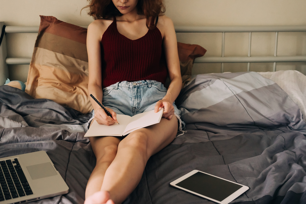 woman writing in bed