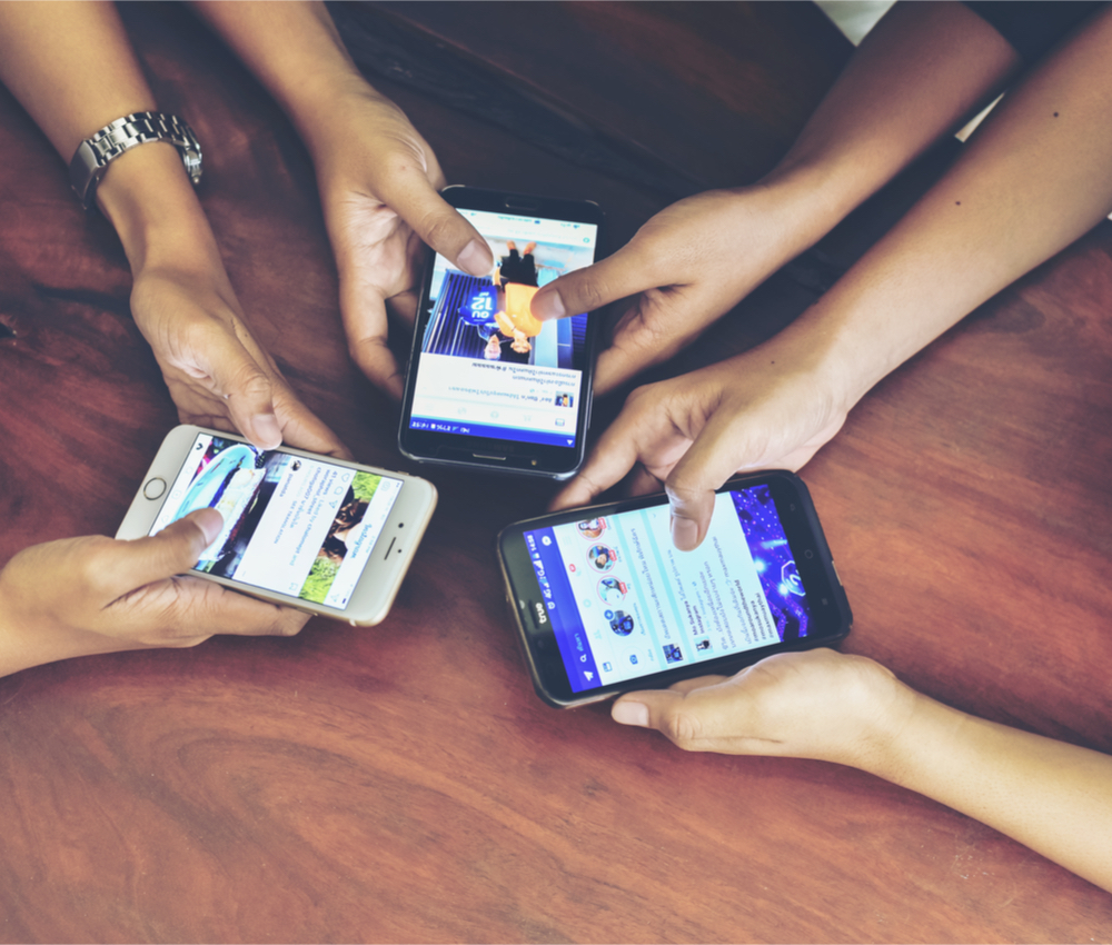 three young people using social media on their smartphones
