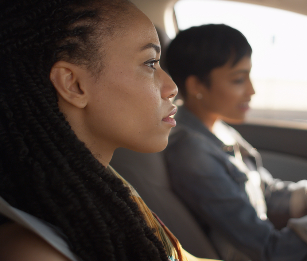 Two women sitting in car talking to each other