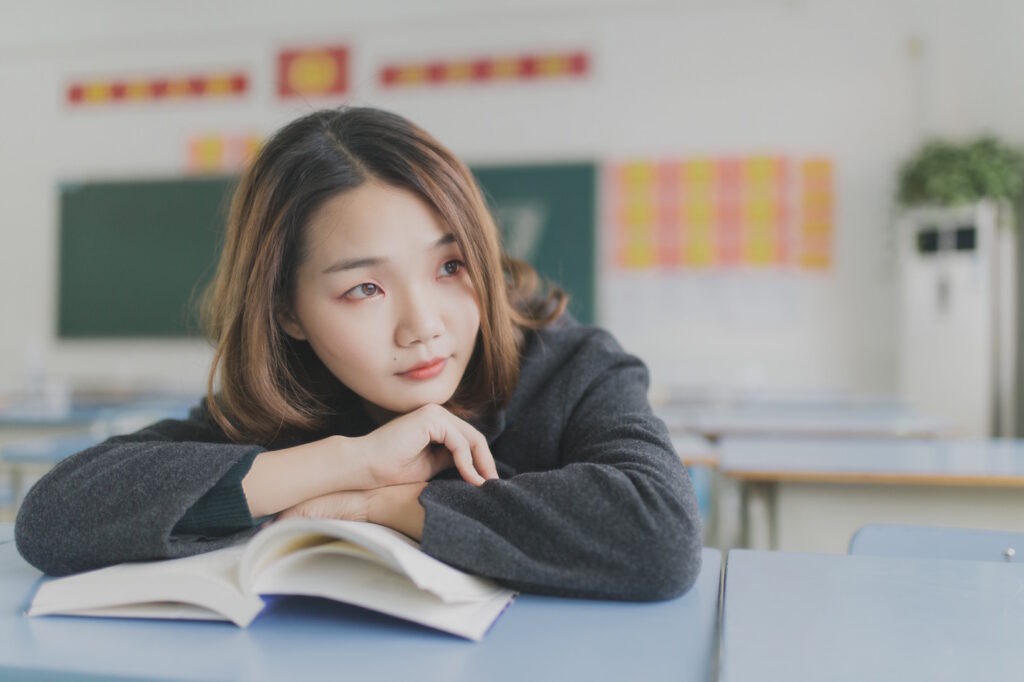 A woman leaning on an open book.