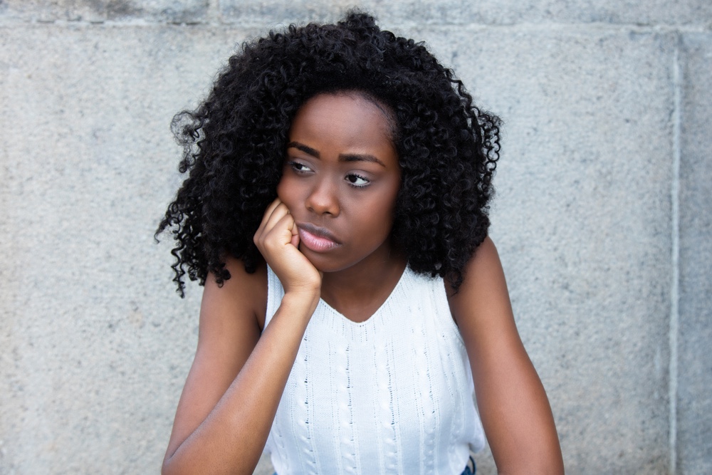 Woman looking to the side, chin on hand.