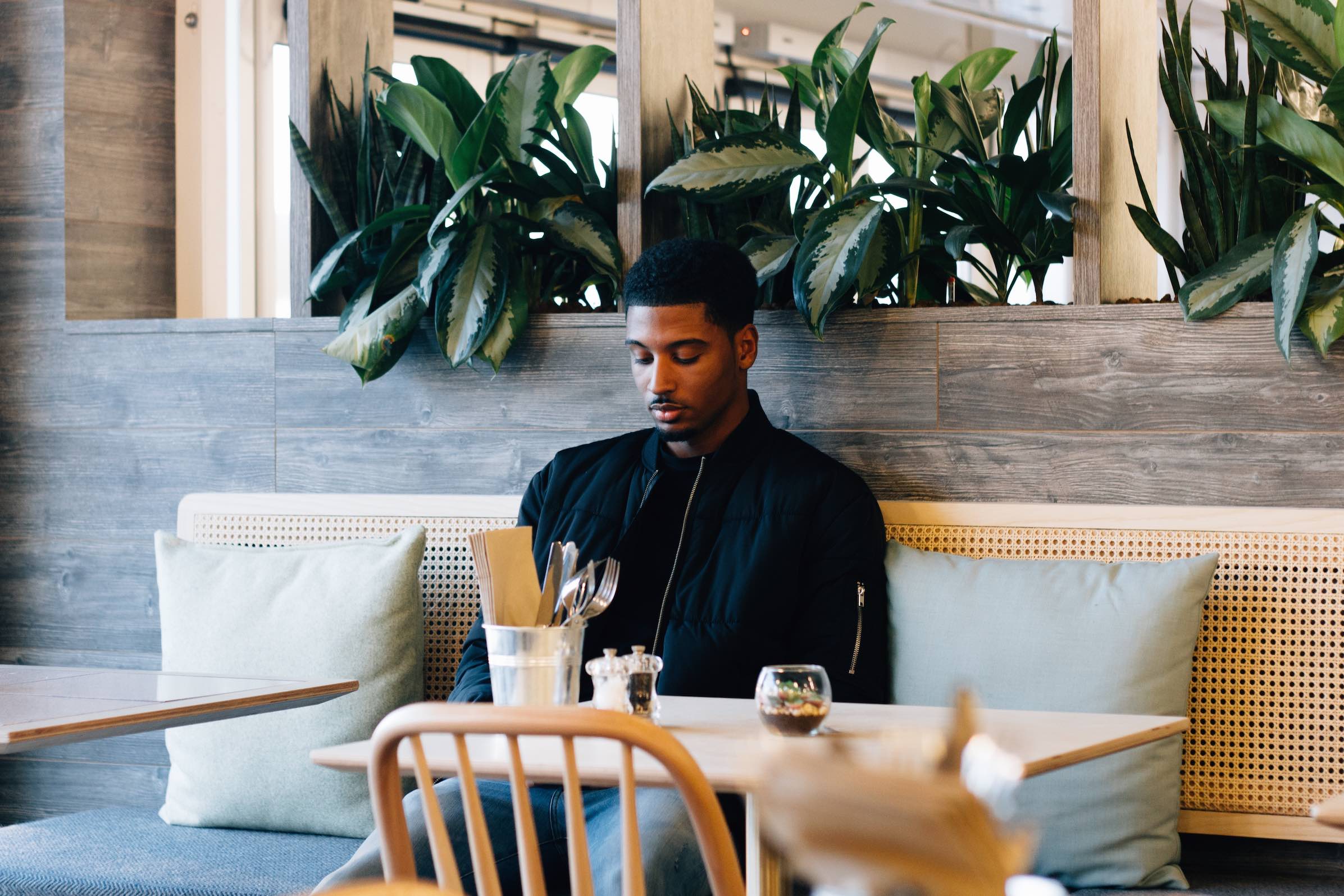 A man sits alone at a table, maybe in a restaurant