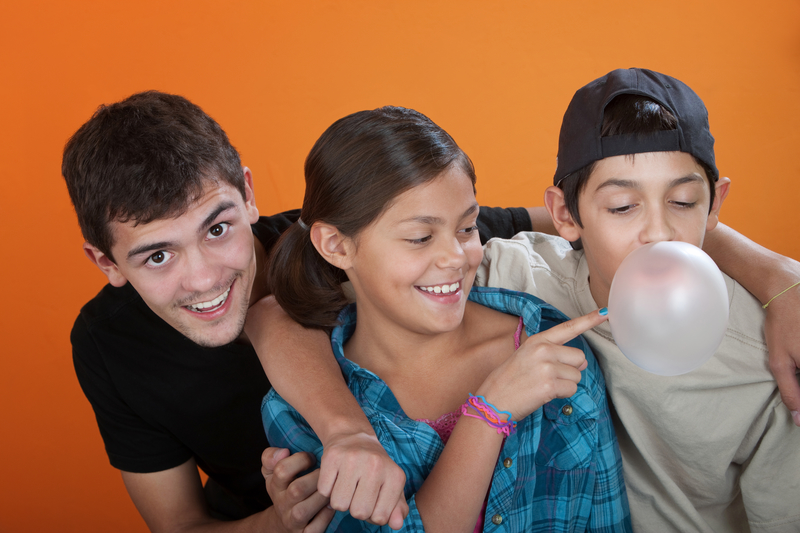 Two boys and a girl smiling, being silly