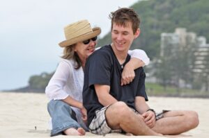 Mom hugging adult son at beach