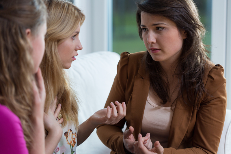 3 women in serious discussion.