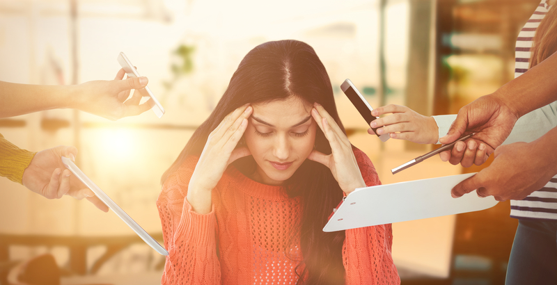 Overwhelmed woman at desk, multiple hands reaching towards her.