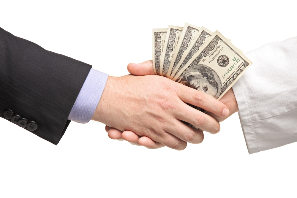 Businessman with money handshaking with doctor isolated on white background