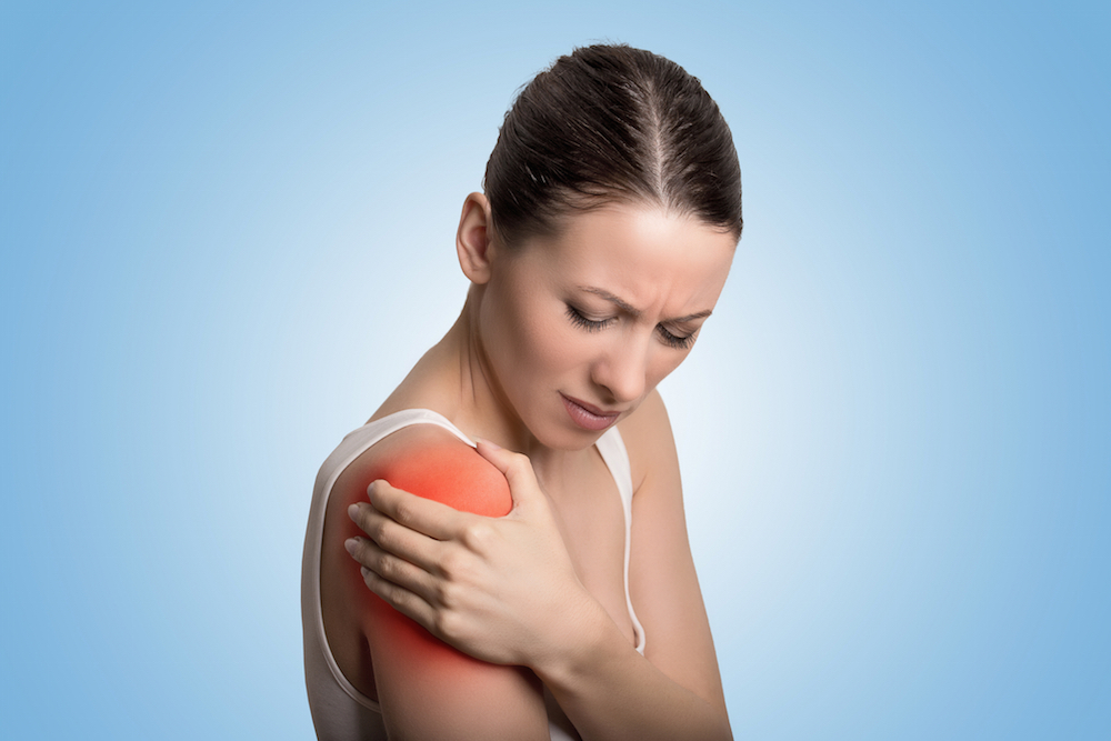 woman grabbing her shoulder in pain