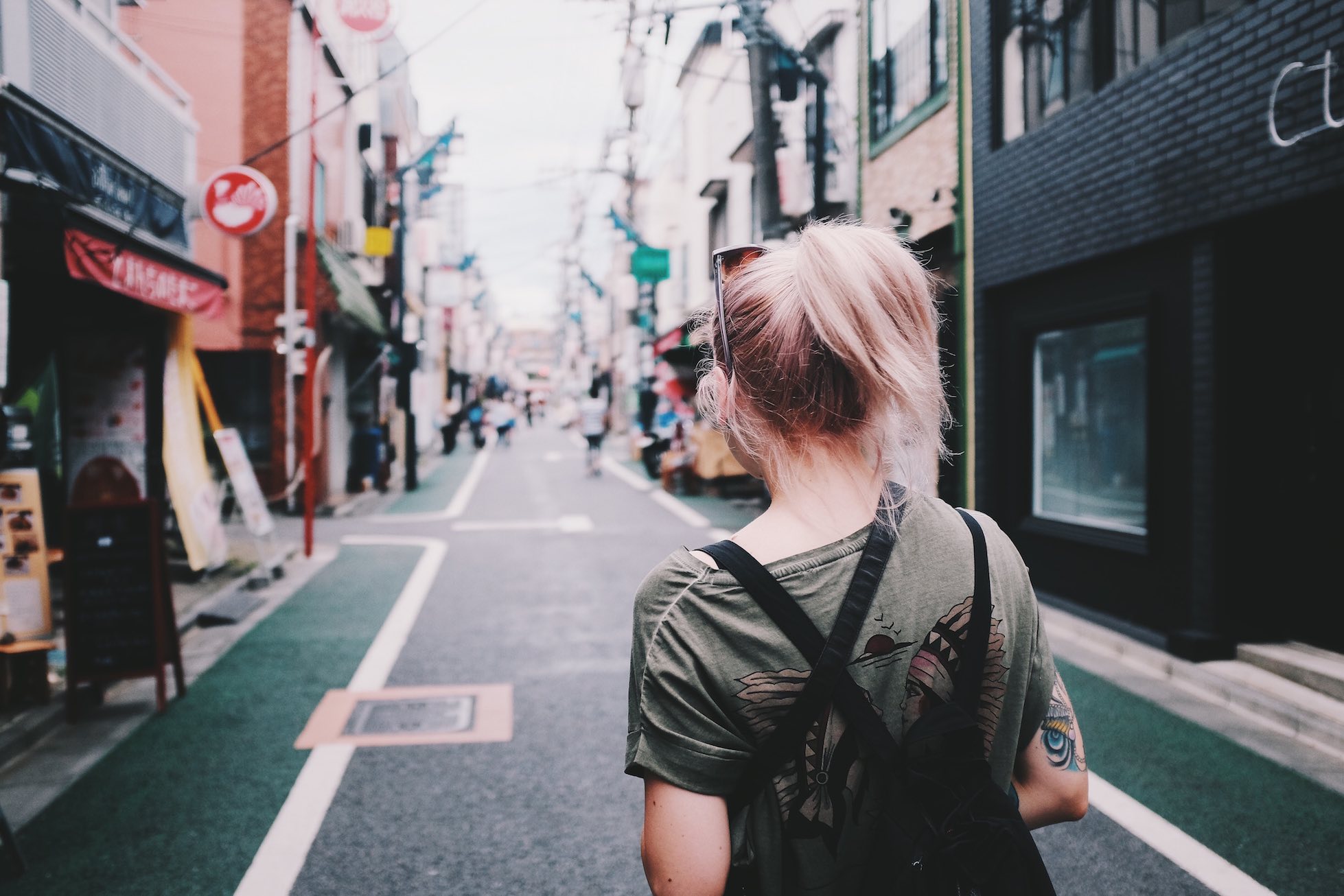 Back shot of a woman walking down a busy street in Japan.