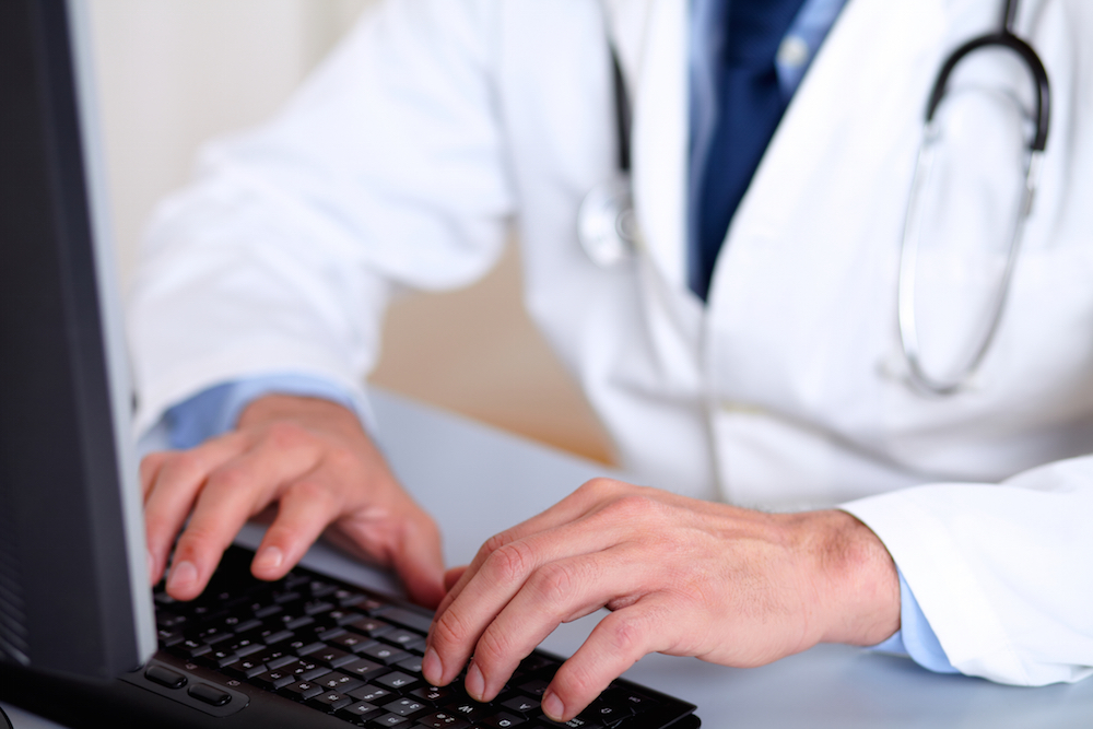 doctor typing on computer keyboard