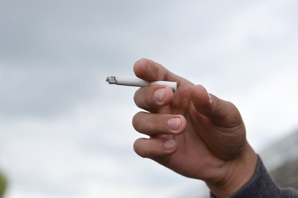 hand holding a lit cigarette
