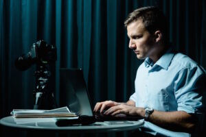 man sitting in dark using laptop