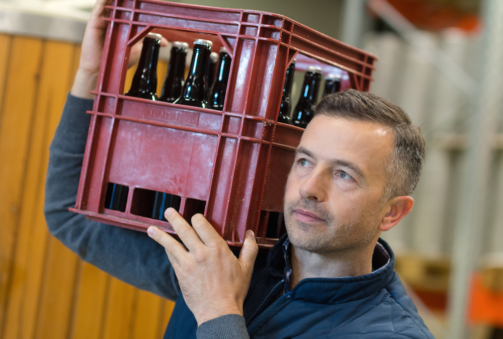 man holding case of alcohol