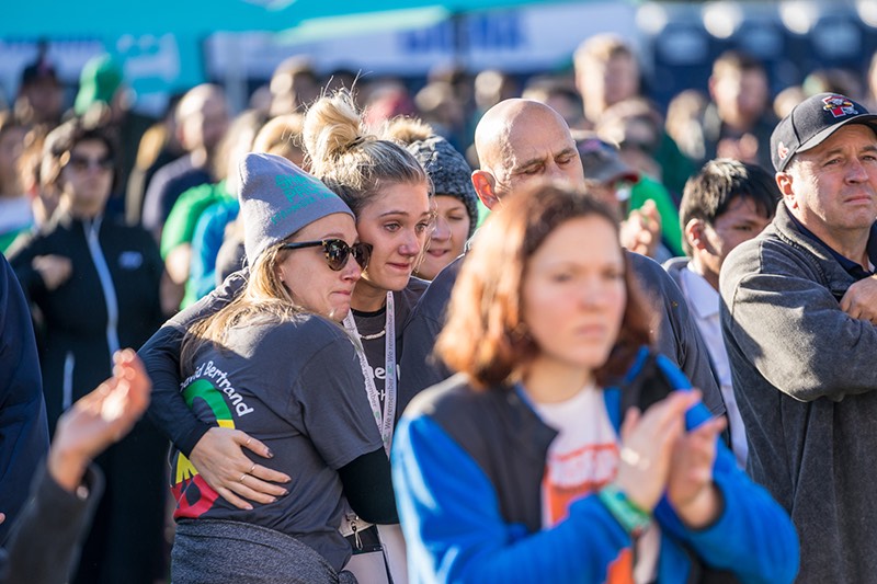 Crowd with people hugging at 5K run.
