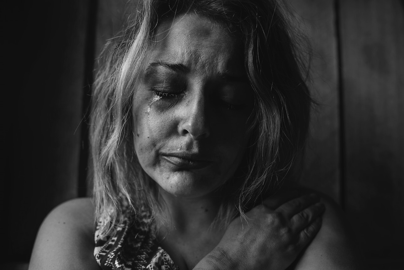 Black & white image of woman's face. She is crying.