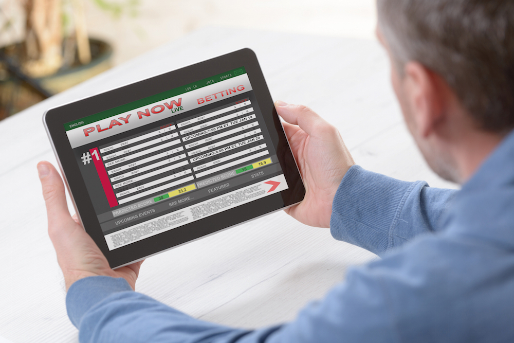Man betting on sports on his tablet