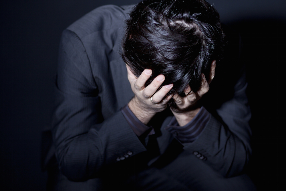 depressed man with head in his hands