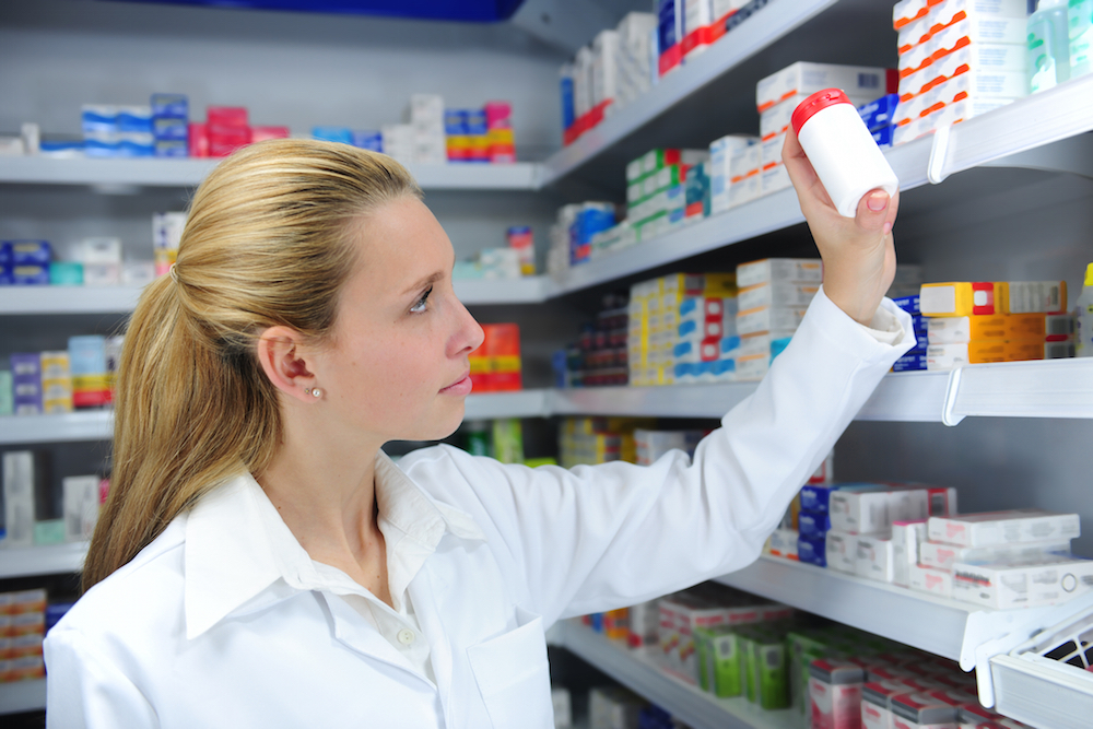 pharmacist selecting a bottle of medication from a shelf