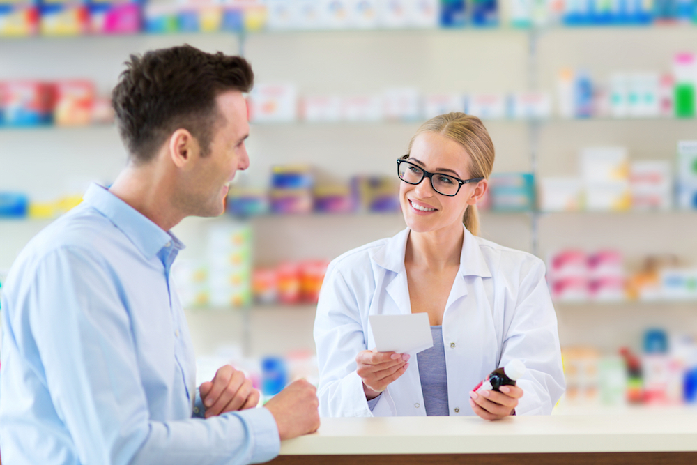 pharmacist and customer talking at pharmacy counter