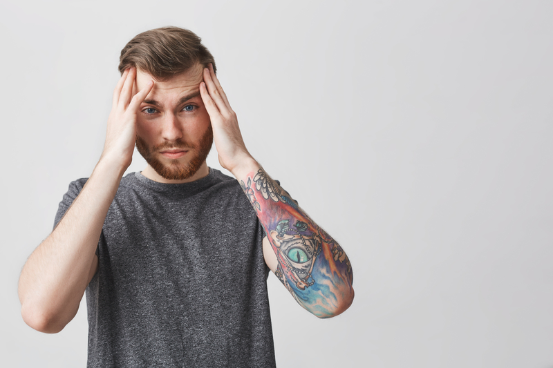 Man holds hands at head, looking confused.