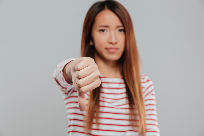 upset woman holding thumb down