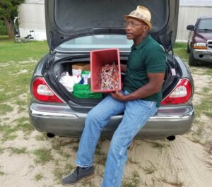 Jessie Garner sitting on car trunk full of items to help people addicted to opioids