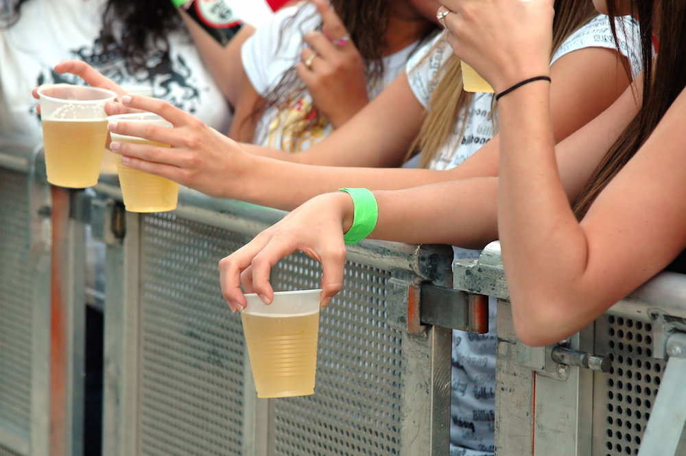 teens holding plastic cups of beer