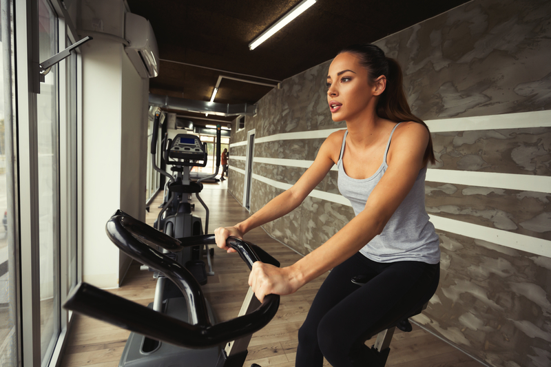 Cardio workout in gym by woman on bike