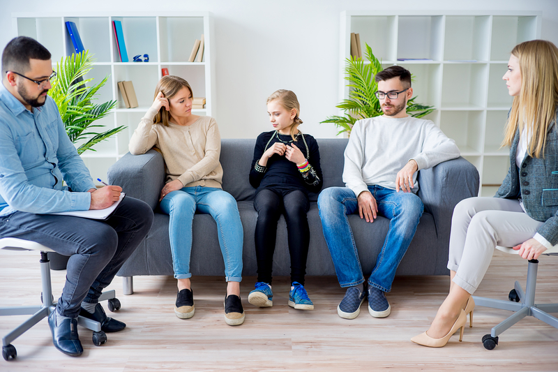 A family sits together as if in family therapy.