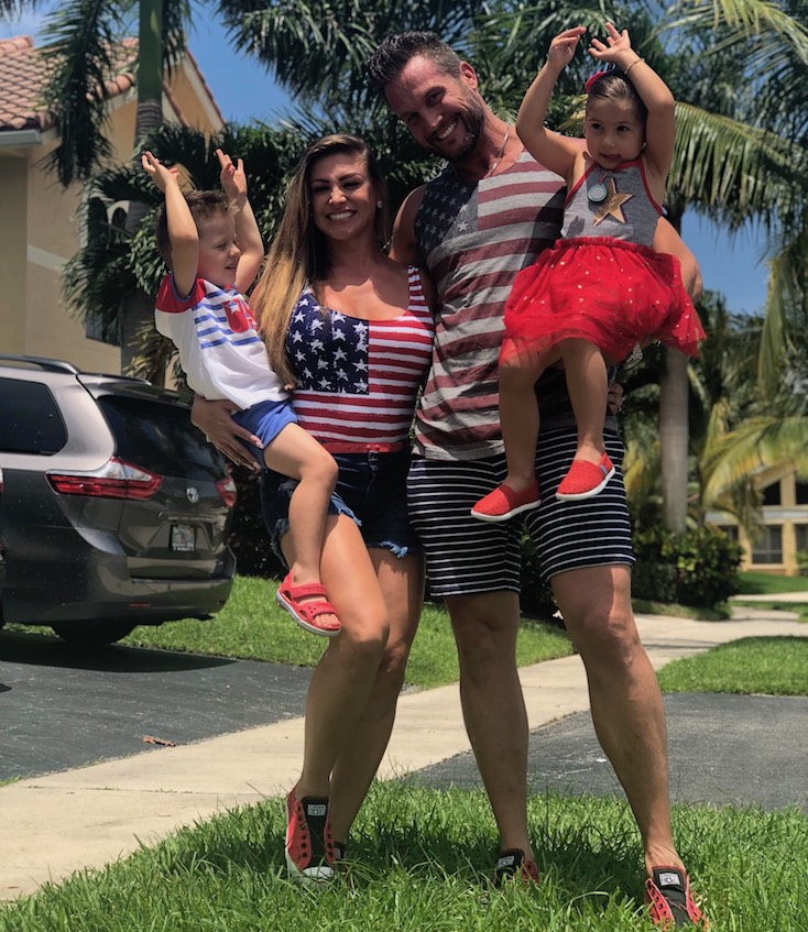 Garren James, his wife, and their two children stand outside, smiling.