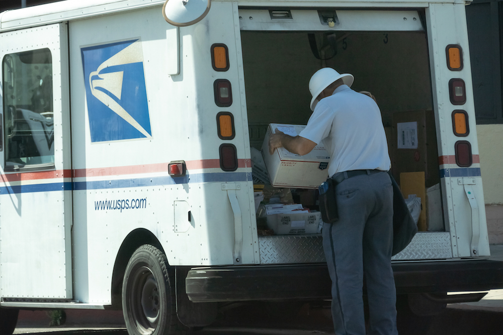 postal worker at the back of mail truck