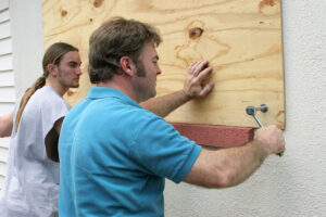 men boarding up a window