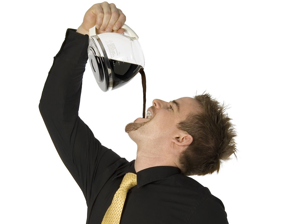 Man pouring the contents of a coffee pot into his mouth