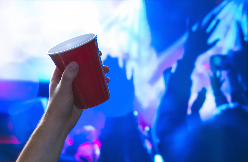 hands hold on to a red disposable cup at a party