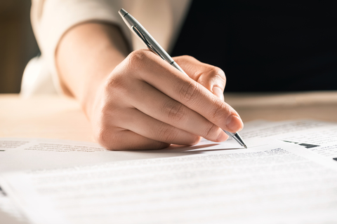 a person signing a paper