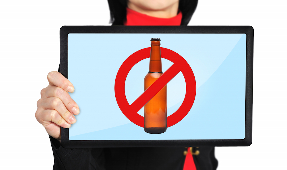 Woman holding touch pad with no alcohol symbol