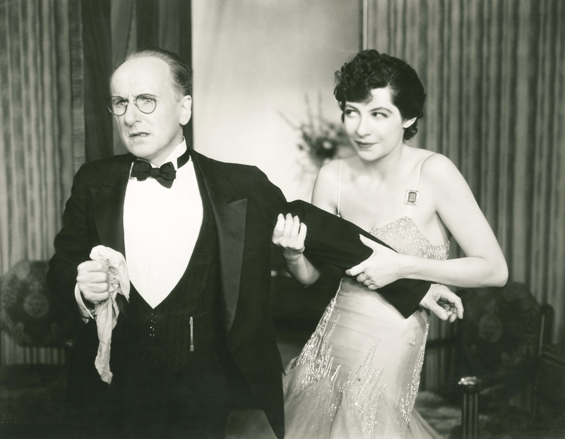 old-timey image of couple in fancy dress, woman pulls man's arm.