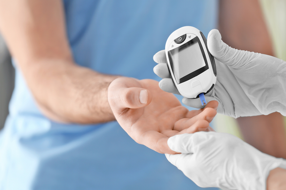 Doctor checking diabetic patient`s blood sugar level.