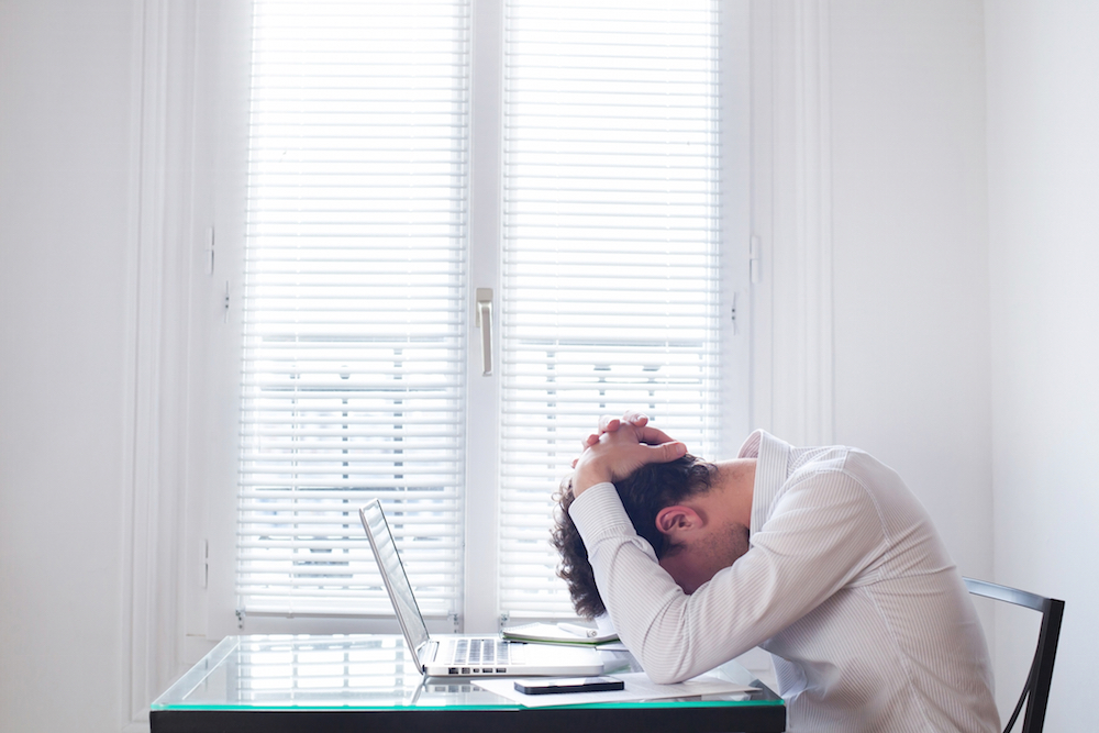 worried man sitting in front of a laptop