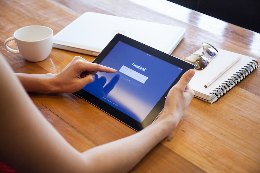 a problematic Facebook user pulling up the app on her iPad.