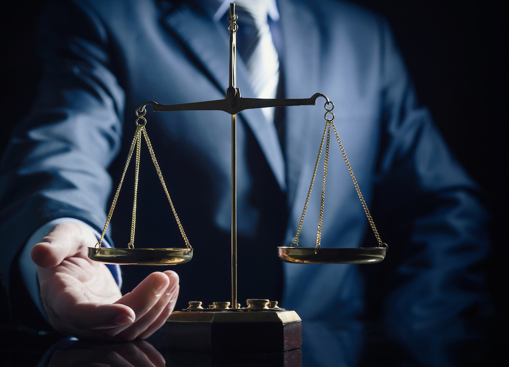 lawyer touches the scales of justice for marijuana cases