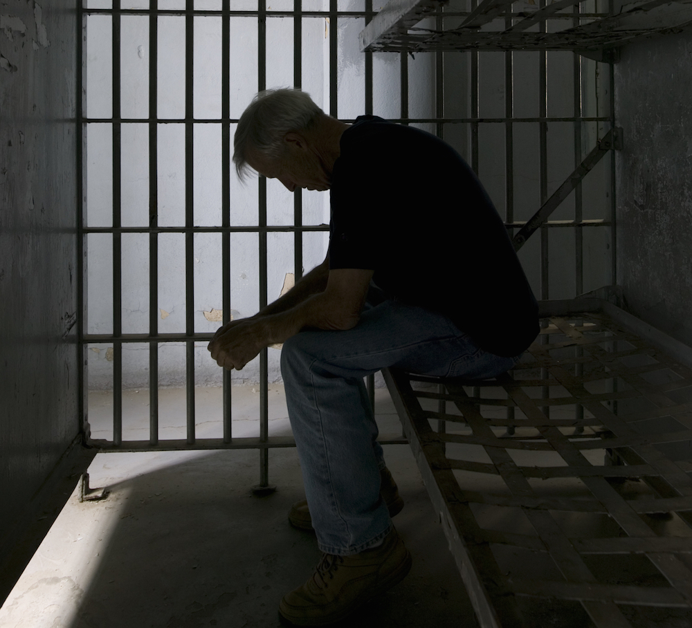 inmate sitting inside of a cell