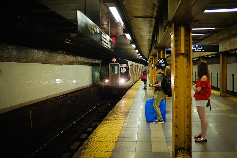 New York residents waiting on the subway platform for a train in need of repairs